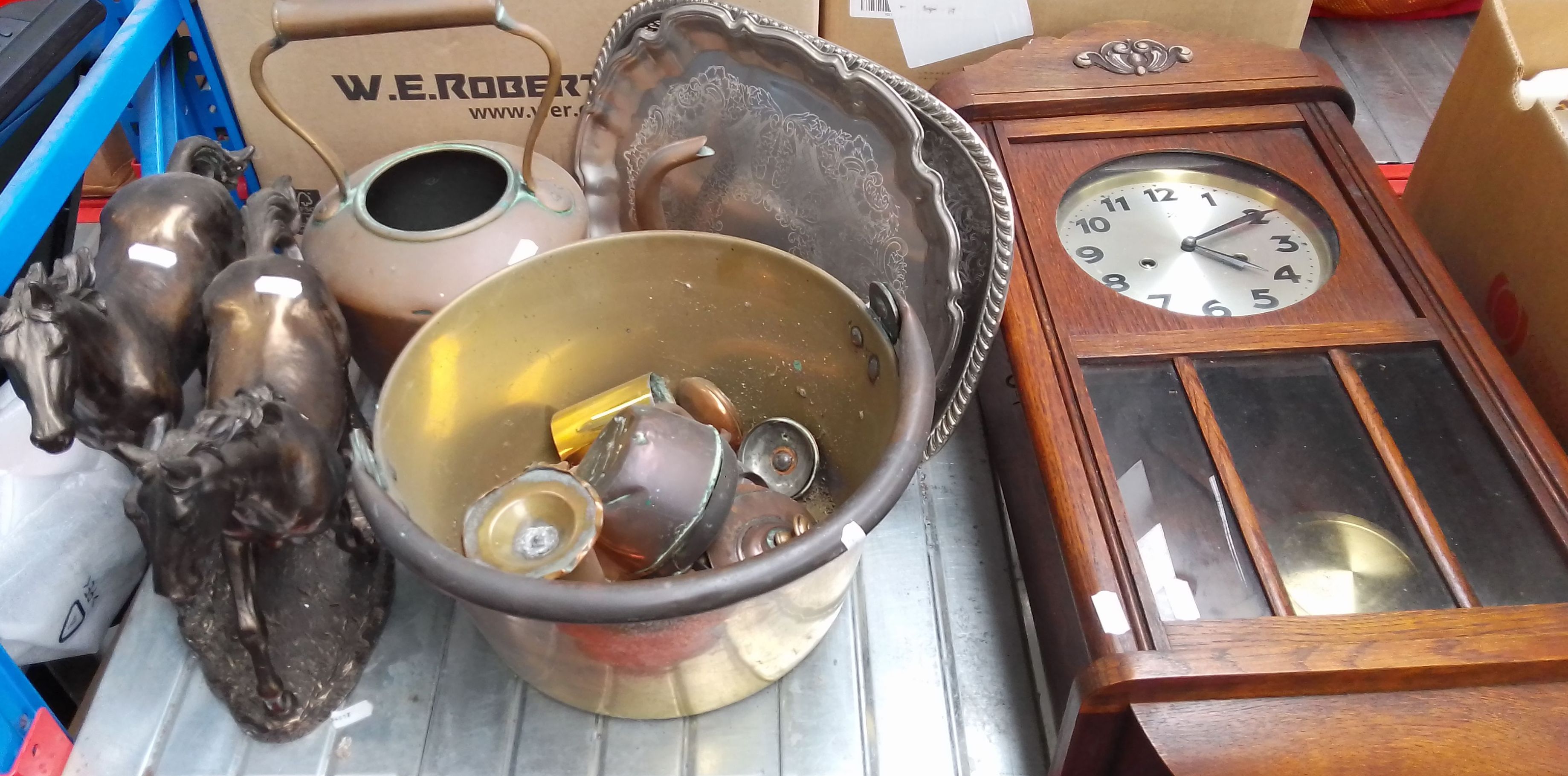 A wall clock, 2 metal salvers, a brass jam pan, a copper kettle, and a composite model of two horses