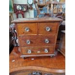 A Victorian mahogany miniature chest of drawers with pressed glass handles.