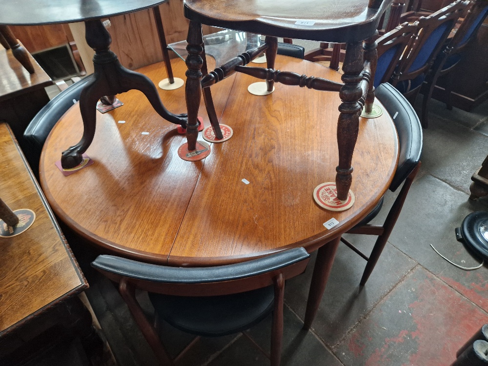 A mid 20th century G Plan teak extending dining table and four chairs.