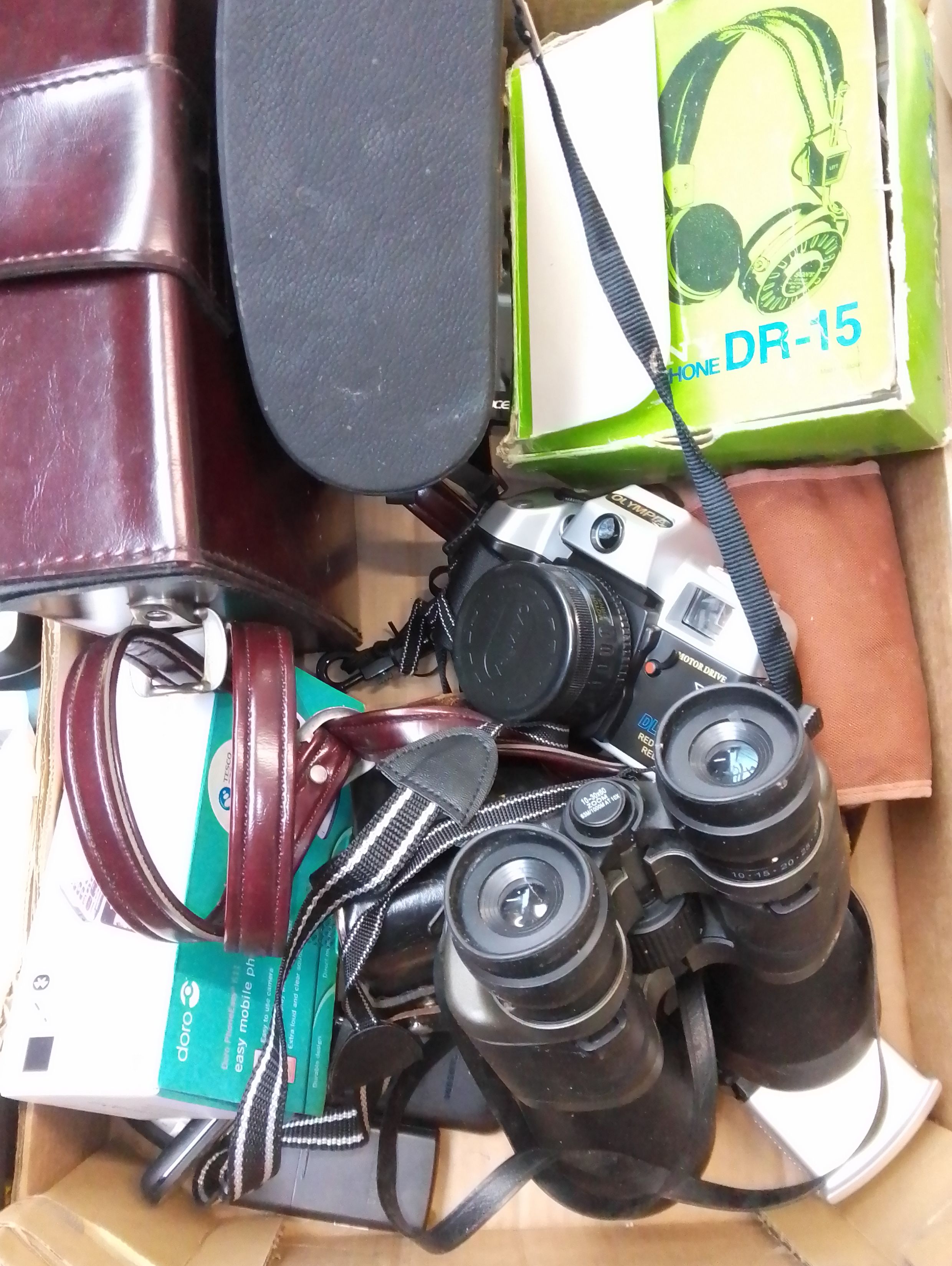 A box of cameras including Zenit, Olympia, binoculars, Acer tablet, headphones, Bolex cine camera