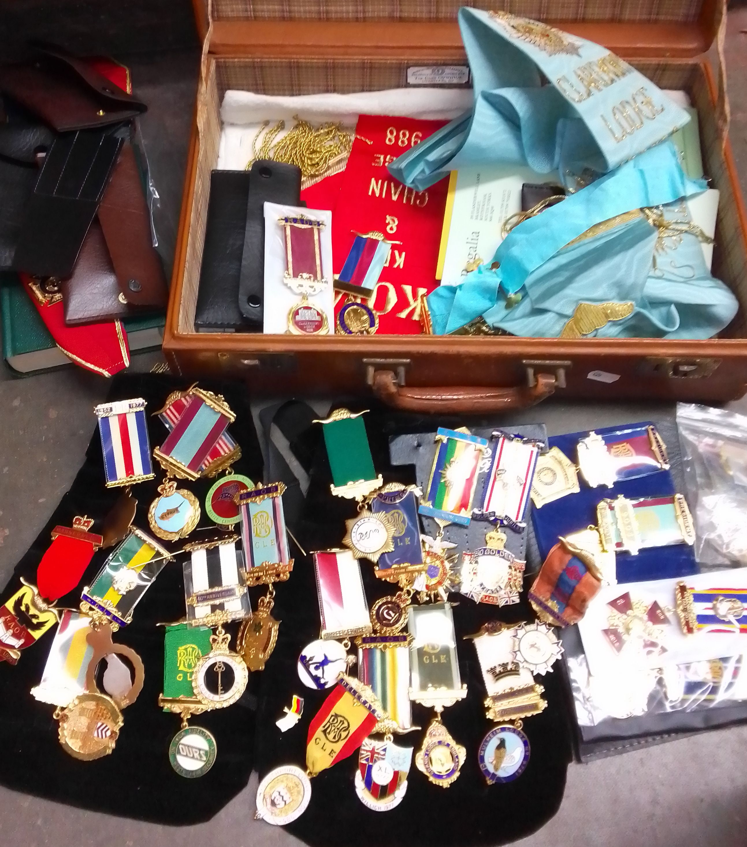 A suitcase containing masonic regalia including medals and a box containing Masonic ledgers