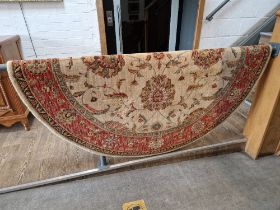 A Chinese wool carpet, cream ground decorated with flowers, diameter 178cm.