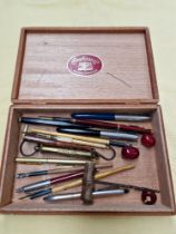 A cigar box and containing various collectables including Parker pens, dip pens, beads, etc.