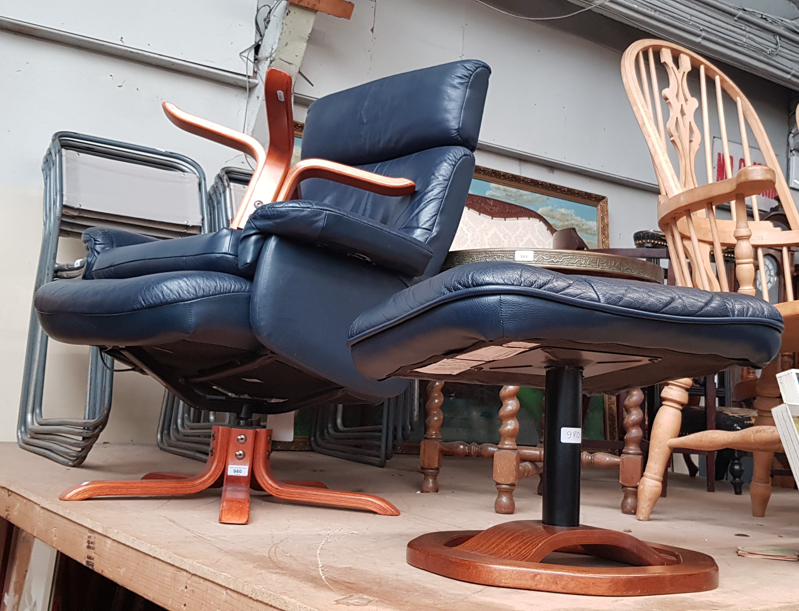 Two Swedish leather swivel lounge chairs with stools.