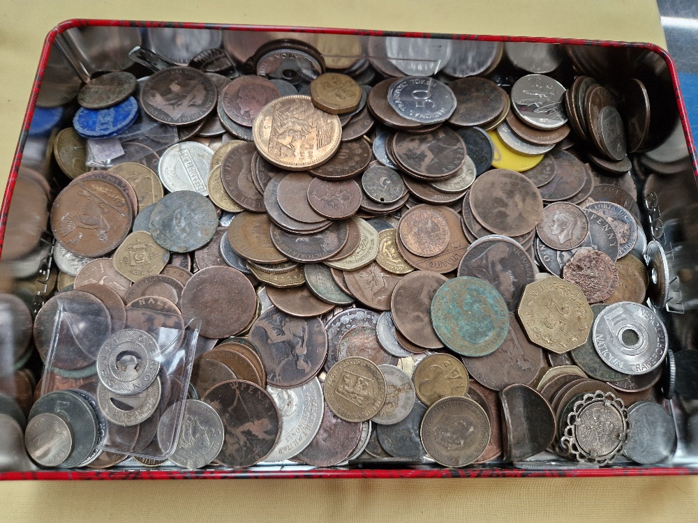 A tin of assorted world coins & tokens