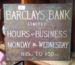 A brass metal plaque with Barclays Bank hours on one side and Ernest Cowpe, Surveyor and Building