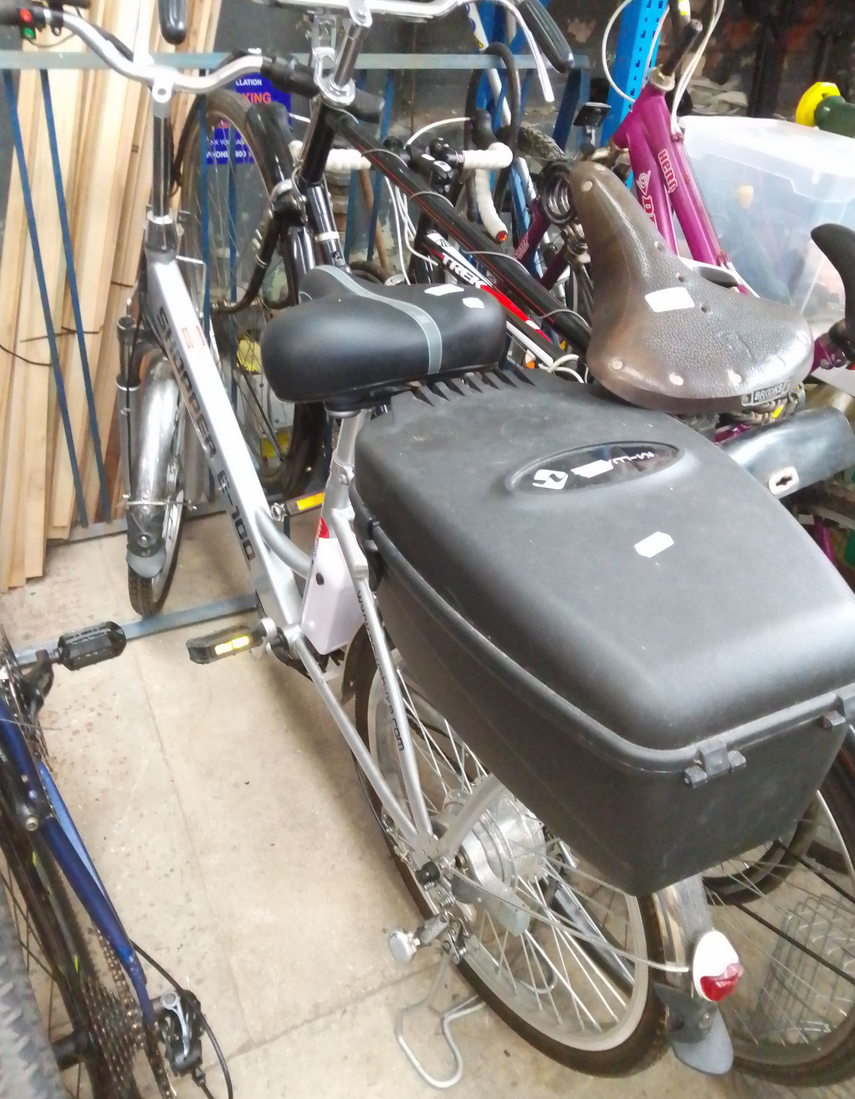 A Powabyke Shopper E-100 electric bicycle with charger and accessories.