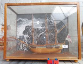A wooden model of a galleon in a perspex case