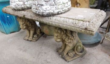 A concrete garden bench on lion plinths