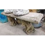 A concrete garden bench on lion plinths