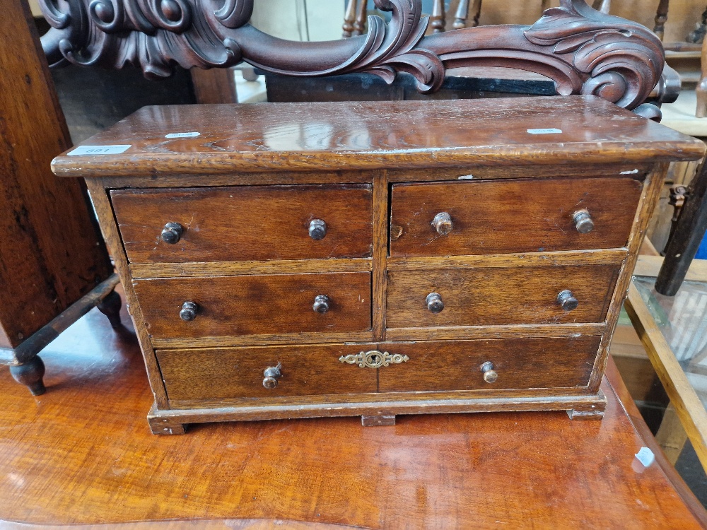 A Victorian mahogany and oak miniature chest of drawers.