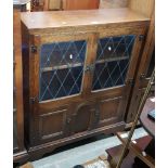 An oak bookcase with leaded glass doors.