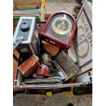 A box of assorted collectables including a camera, a pair of binoculars, a clock, a cast metal money