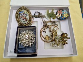 A box of jewellery including vintage brooches and a silver brooch.