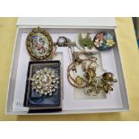 A box of jewellery including vintage brooches and a silver brooch.