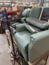 A pair of green leather electric recliner armchairs.