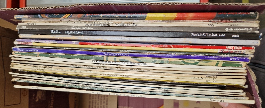 A box of vinyl LP records, rock and pop including ELO, Phil Collins, Bruce Springsteen, Jean