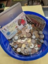 A tub of assorted world coins and banknotes