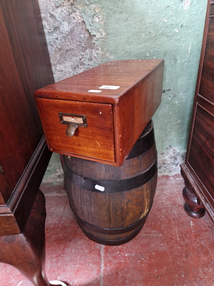A vintage wooden filing drawer and a metal bound barrel.
