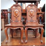 A pair of 19th century oak hall chairs with cabriole legs.
