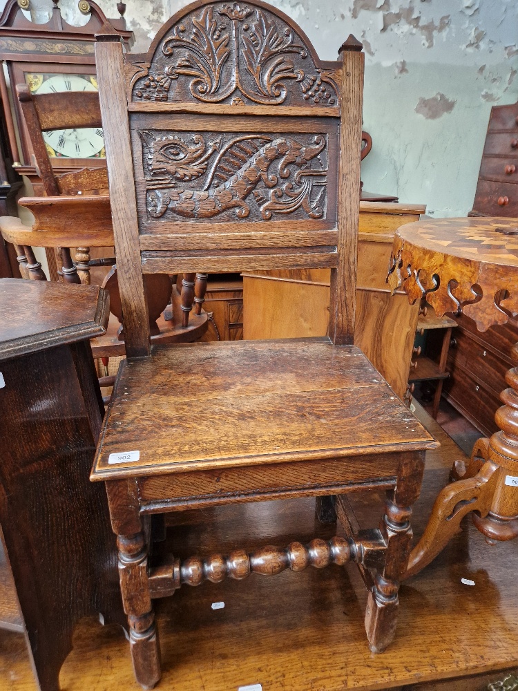 An 18th century carved oak chair with dragon to the back.