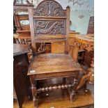 An 18th century carved oak chair with dragon to the back.