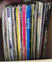 A box of vinyl LP records, rock and pop including The Jam, Toya, Simple Minds, Strawbs, Elvis