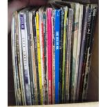 A box of vinyl LP records, rock and pop including The Jam, Toya, Simple Minds, Strawbs, Elvis