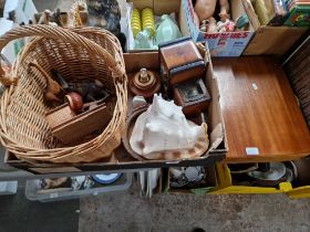 A box of assorted collectables including carved wood, a basket, a large conch shell, novelty