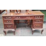 An Edwardian mahogany desk with tooled leather writing surface, the locks marked 'RC&S' with a