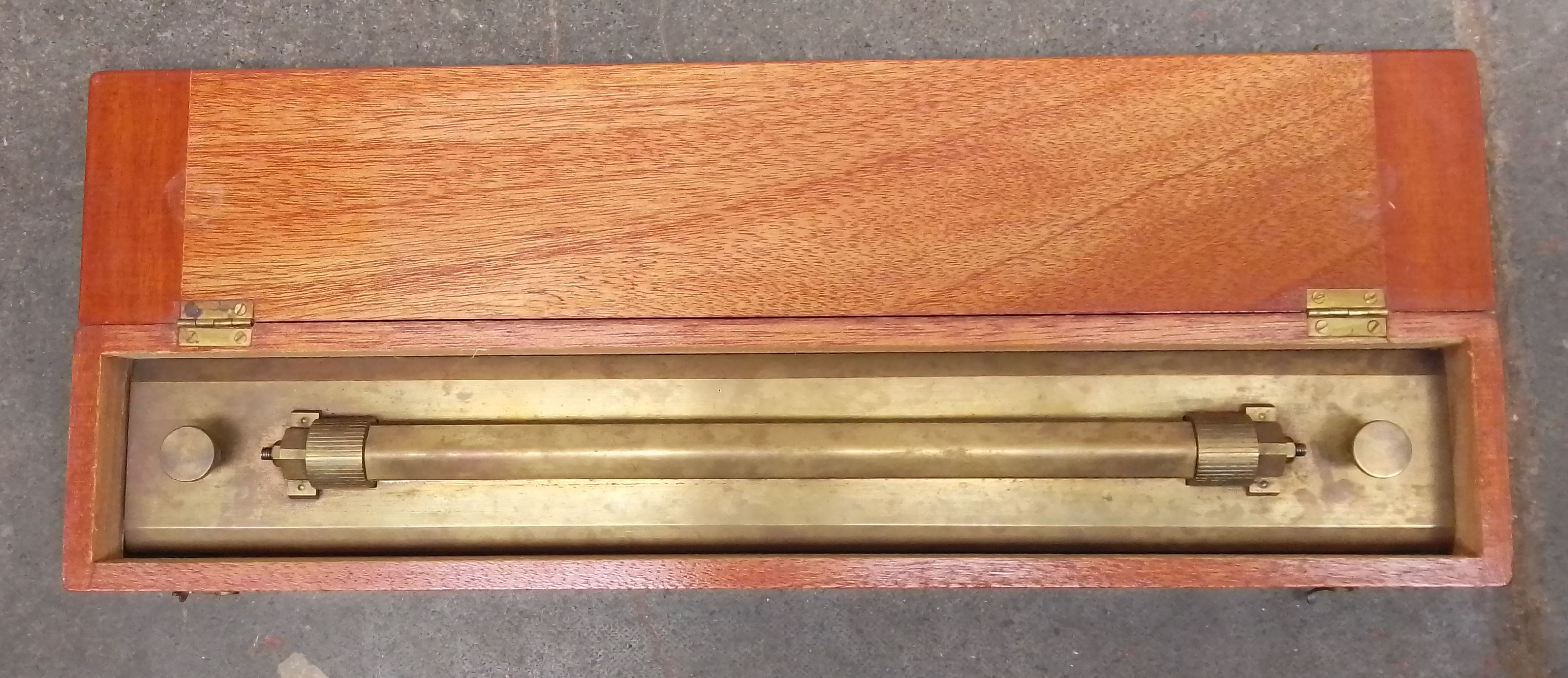 An early 20th century brass rolling rule in mahogany case.