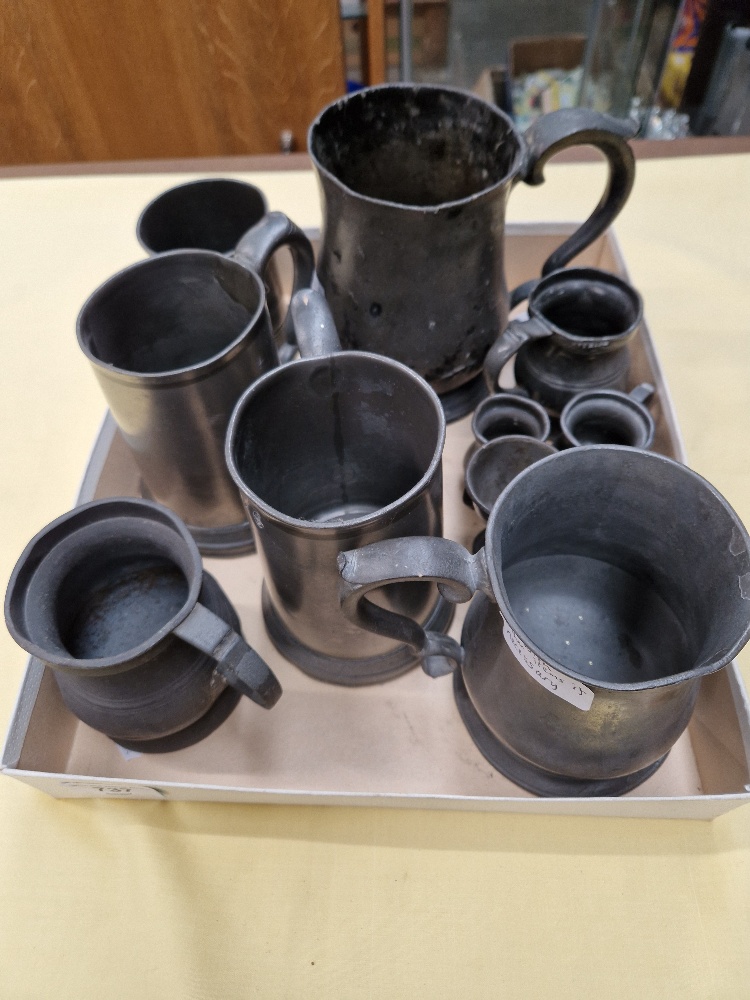 A box of assorted pewter tankards.