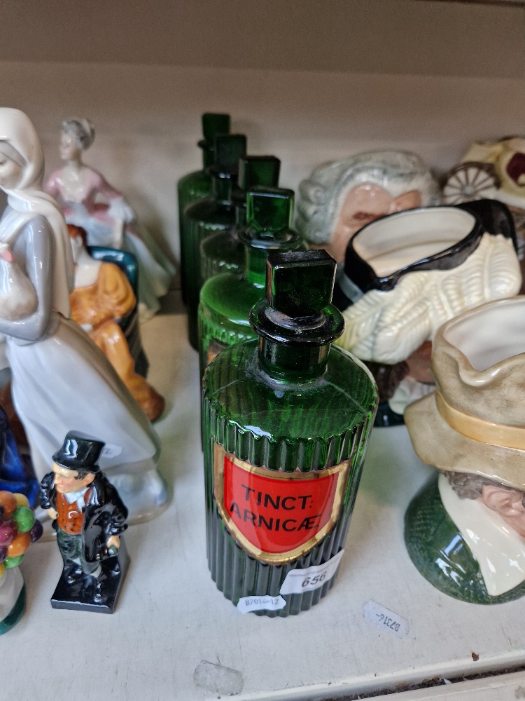 A group of five green apothecary bottles
