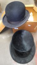 An antique top hat and a bowler hat.