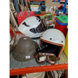 A WWII helmet and two motorcycle helmets.