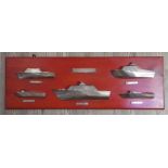 A display of cast silver half hull boats, modelled after boats produced by Anchorage Ltd,