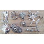 A collection of nine silver brooches.