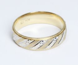 A two colour wedding band, marked '10K', weight 5.1g, size U.