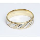 A two colour wedding band, marked '10K', weight 5.1g, size U.