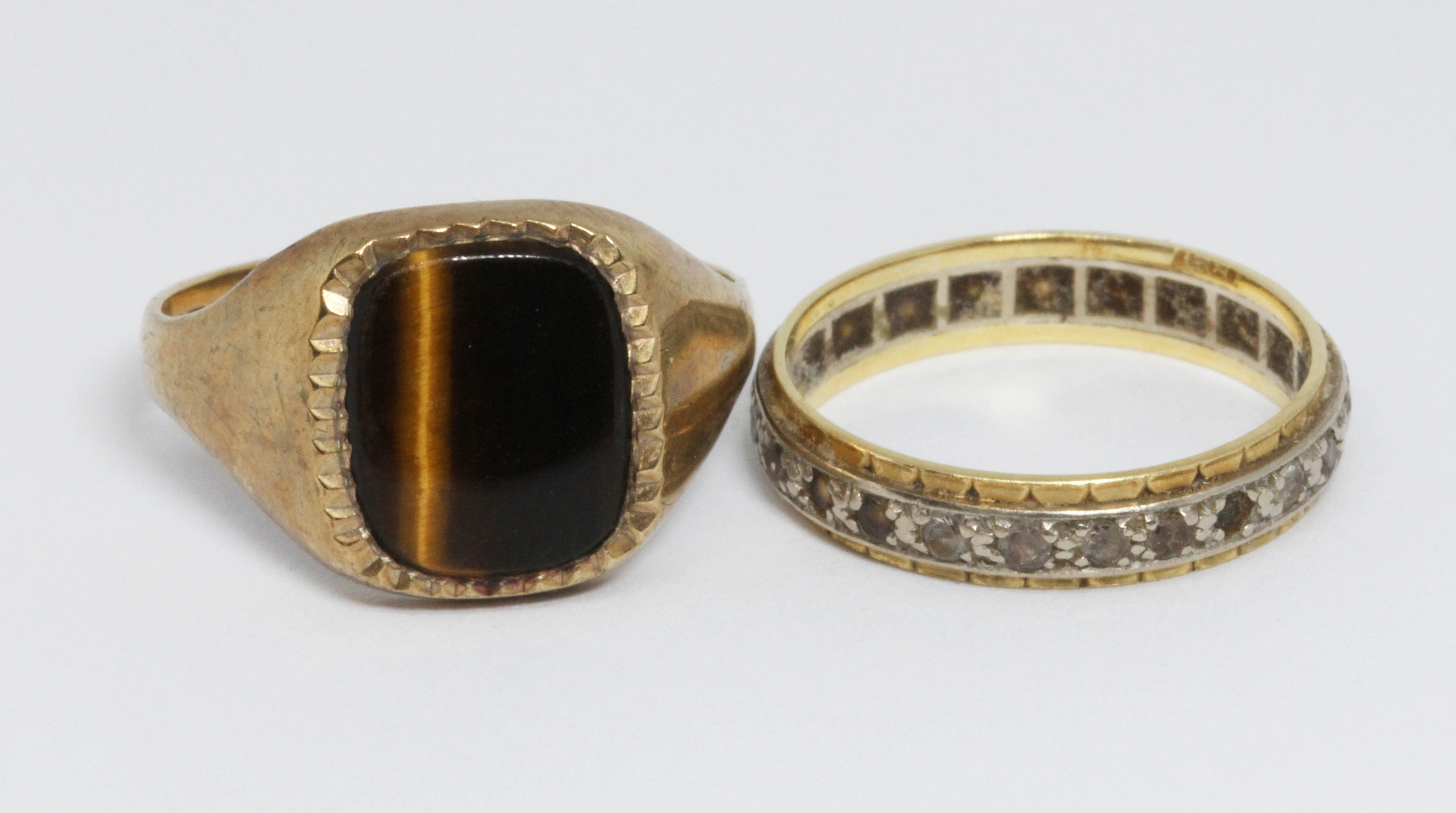 A hallmarked 9ct gold tiger's eye signet ring, weight 3.5g, and a colourless stone eternity band,