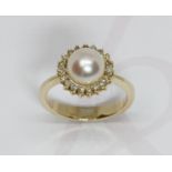 A cultured pearl and diamond cluster ring, the full pearl measuring approximately 8mm in diameter,