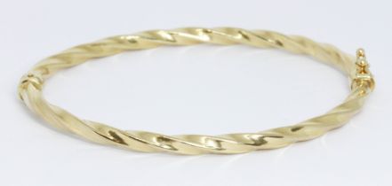 A 9ct gold twist bangle, international convention marks, diameter approximately 6cm, weight 4g.