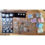 A collection of UK and world coins including cased coin sets and banknotes.