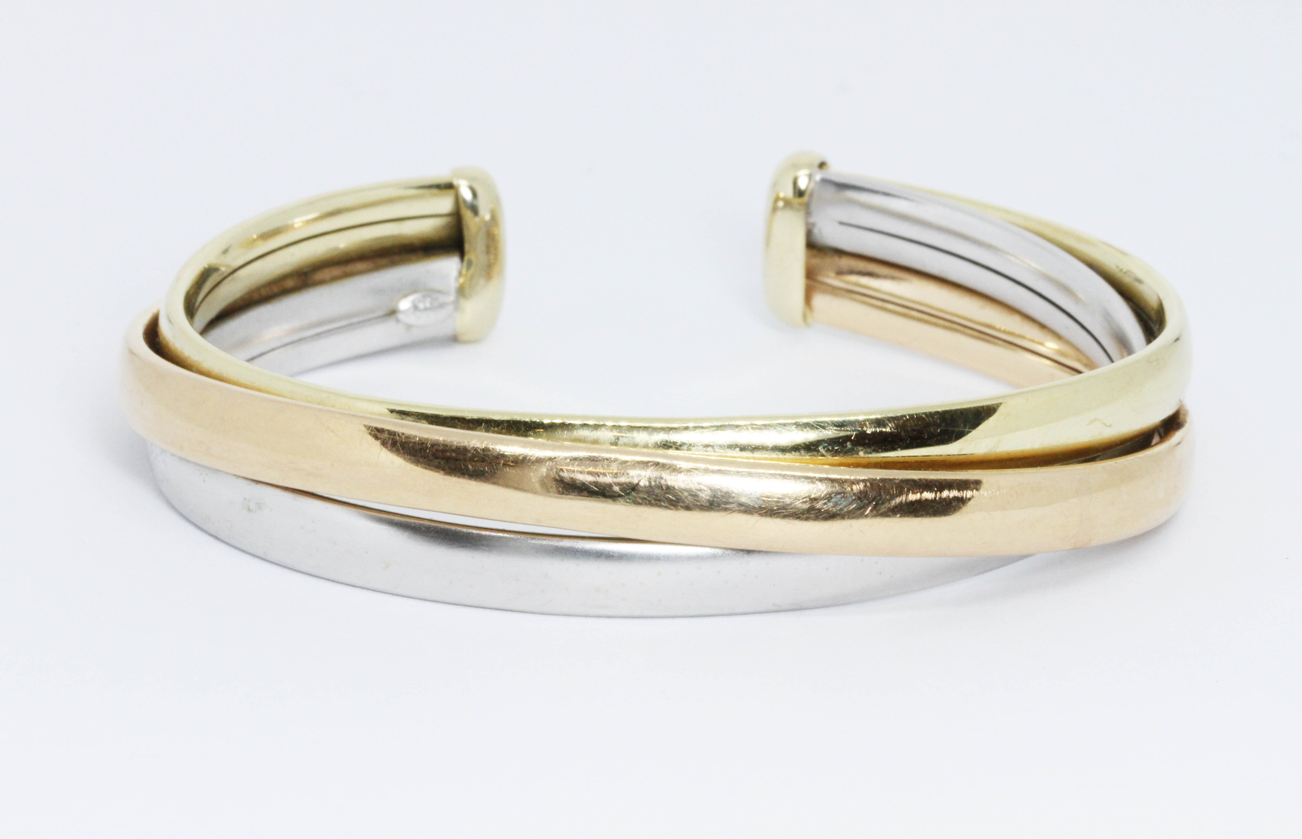 A three colour bangle, marked 'CETAS 585', diameter 6cm, weight 23.2g. Condition - good, minor