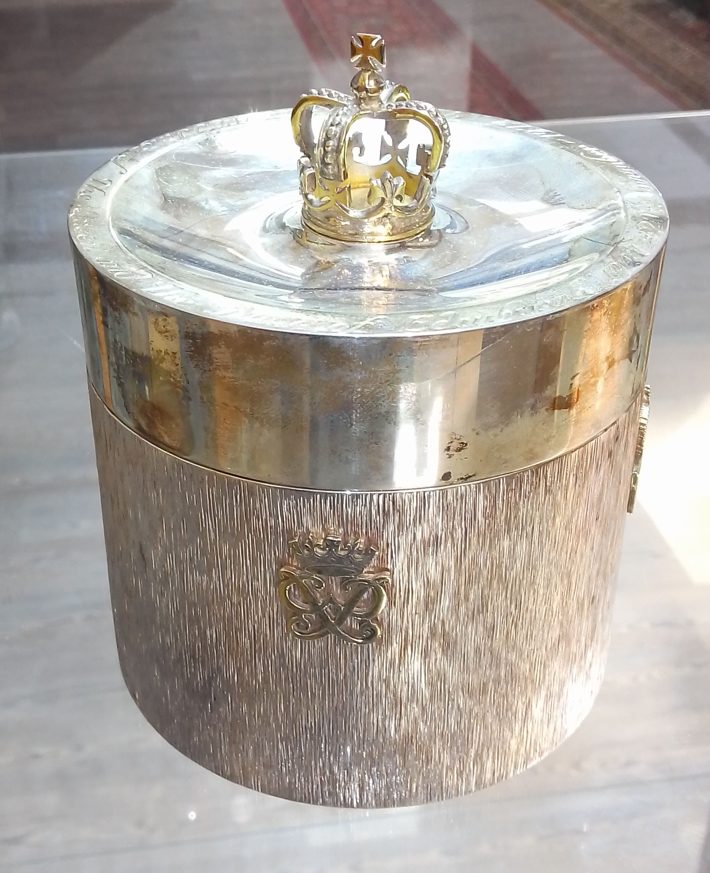 An Elizabeth II Silver Wedding commemorative silver tea caddy, gilt crown finial, textured body with