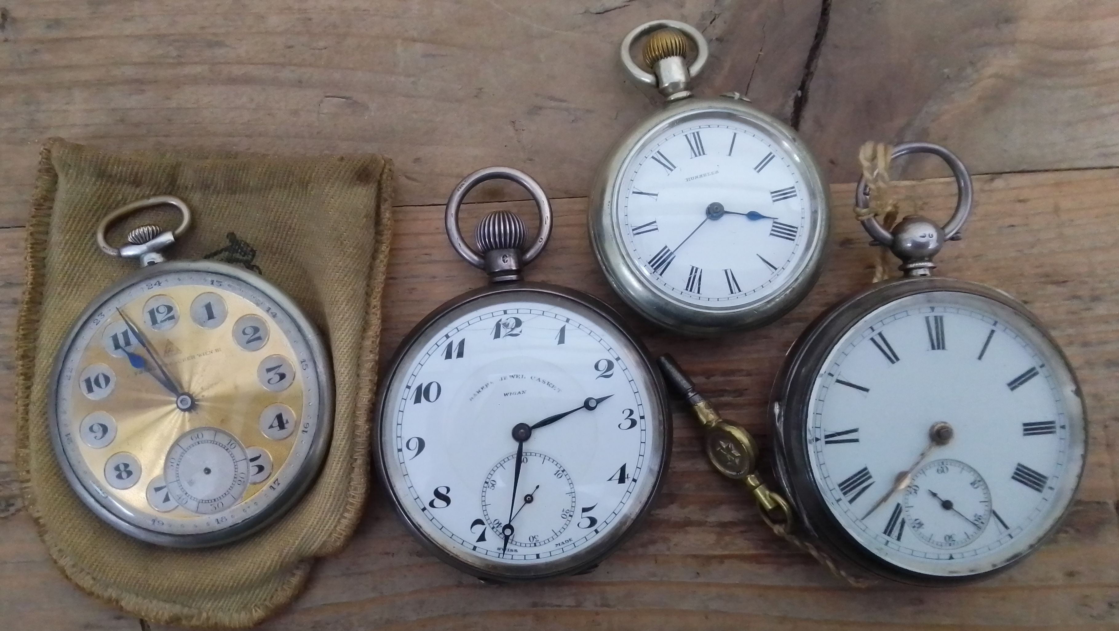 Three silver pocket watches and another.