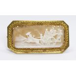 A yellow metal cameo brooch, the rectangular shell cameo depicting figures riding a chariot with