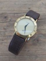 A ladies gold plated Gucci wristwatch, case diameter 33m, leather strap. Condition - not currently