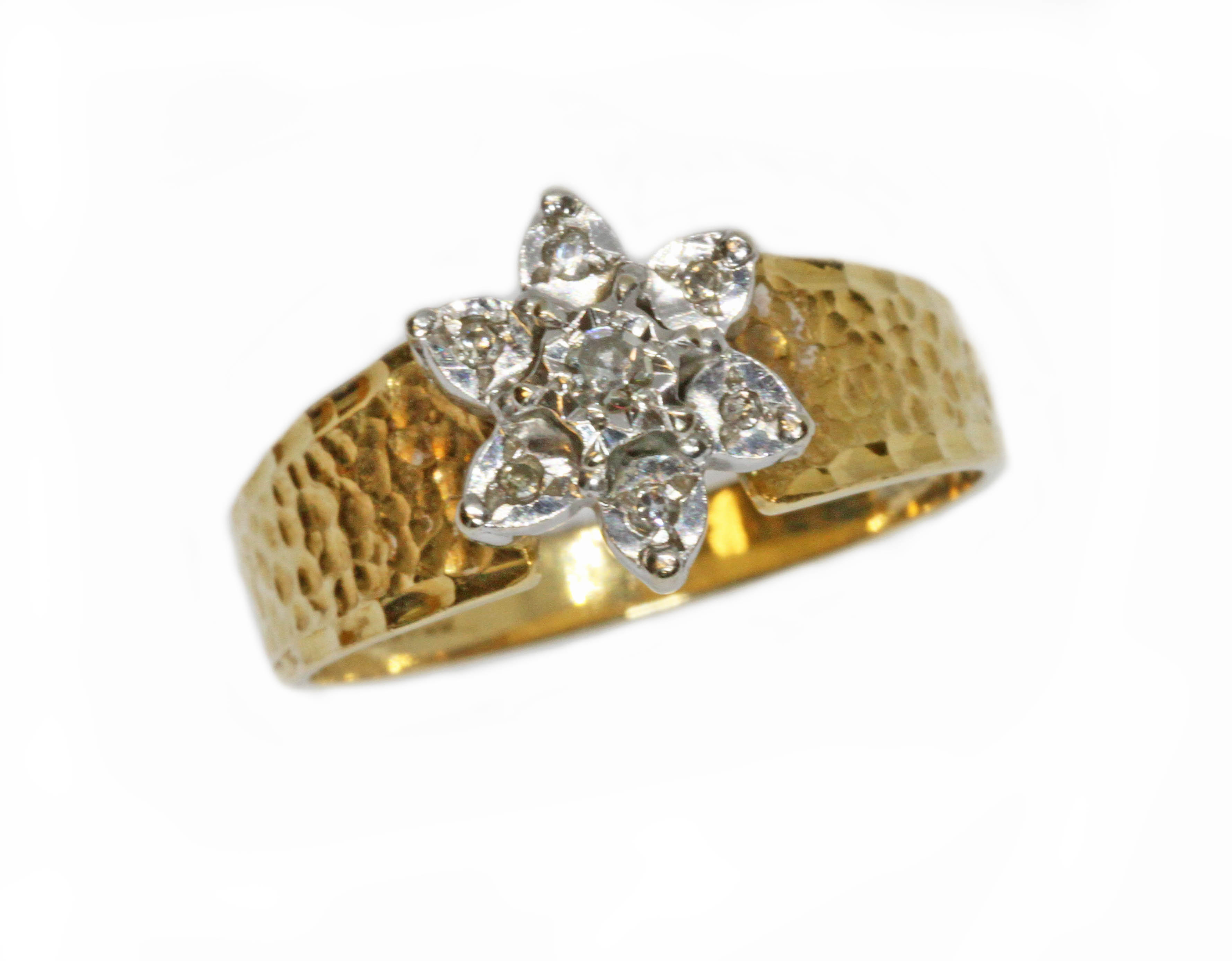 A hallmarked 18ct gold diamond cluster ring, the flower head cluster measuring approximately 10mm in