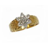 A hallmarked 18ct gold diamond cluster ring, the flower head cluster measuring approximately 10mm in